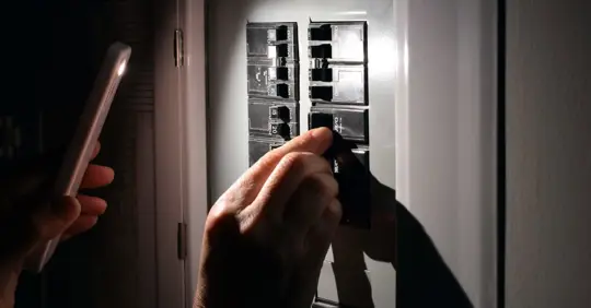 Person switching electrical breaker panel