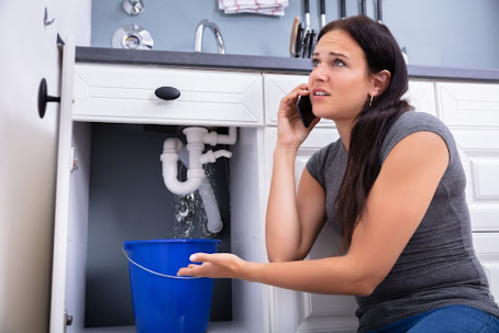 woman on phone for help with leaking sink