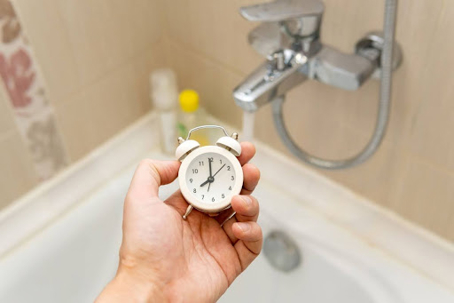 man timing hot water in bathroom