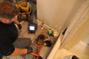 A Big Brothers Home Services plumber performs a sewer inspection in a home.